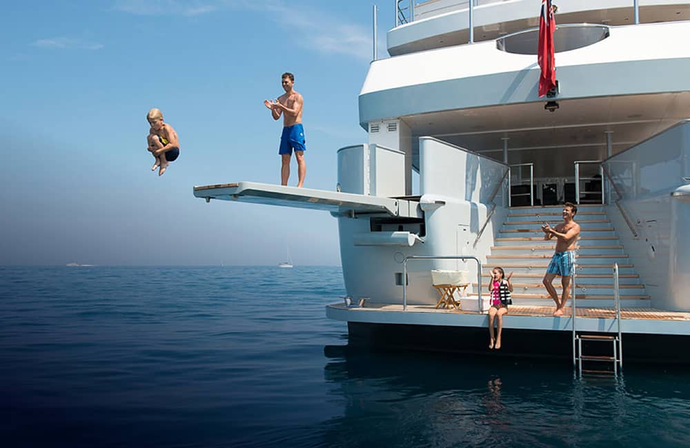 Guests on Idol going off diving board attached to back of yacht
