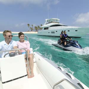 A couple in a boat and a couple jet skiing