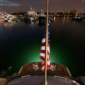 Stern view in the evening with green lighting and a US Flag