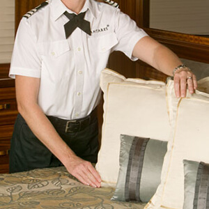 Yacht Head of Housekeeping adjusting pillows