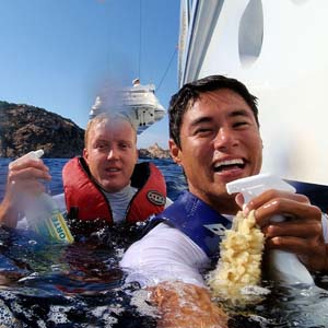 deckhands washing yacht hull from the water